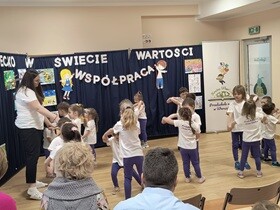 Dzieci wraz z nauczycielką tańczą w parach trzymając się za ręce.